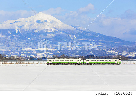 磐梯山と雪原を走る只見線の列車　福島県会津美里町 71656629