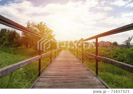 Empty wooden brige in village, sunset sky. Empty wooden brige in village, sunset sky. 71657325