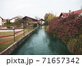 Small river goes in village between houses, autumn season. 71657342