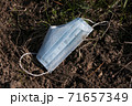 face mask drop on ground grass floor, save the nature. garbage. in time of coronavirus 71657349