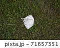 face mask drop on ground grass floor ,epidemic, save the nature. garbage. 71657351