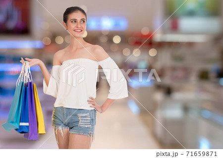 woman holding many colorful shopping bags over Shopping malls background.  71659871