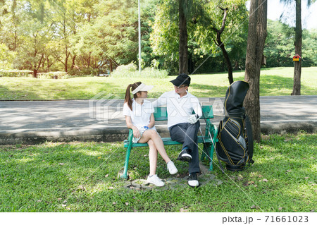Male and female golfers talking and plan for play golf in the lawn, sitting relax on chair  71661023
