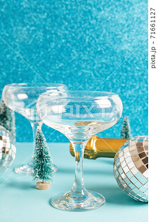 Christmas minimal festive background with disco ball, toy tree, glasses of champagne. Abstract glitter Christmas and New Year color background blue ai aqua. Bright sparkling wallpaper texture. 71661127