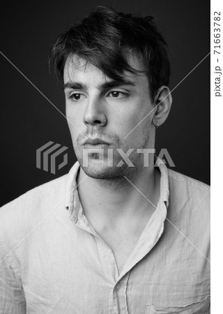 Studio shot of young handsome man against gray background 71663782