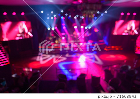 Blurred nightclub with spotlights beaming on the dance floor 71663943