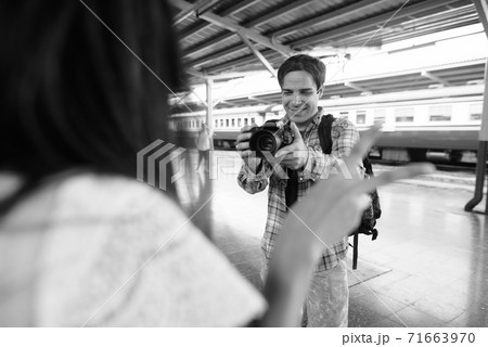 Persian tourist man and young Asian tourist woman together at the railway station Persian tourist man and young Asian tourist woman together at the railway station 71663970