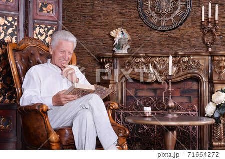 Portrait of mature man reading book at room 71664272