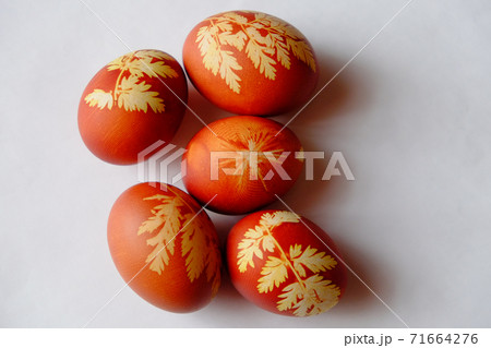 Painted Easter eggs on a white background. Floral pattern on a red eggshell. Festive food. 71664276