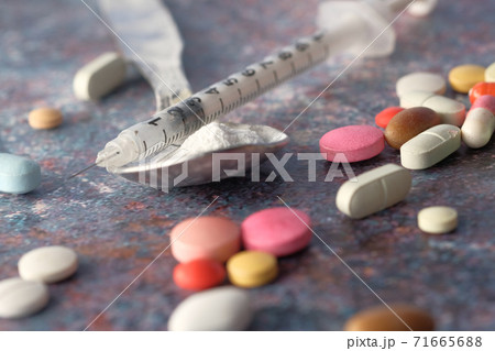 drug addiction concept with heroine packet and syringe on black backgrund  71665688