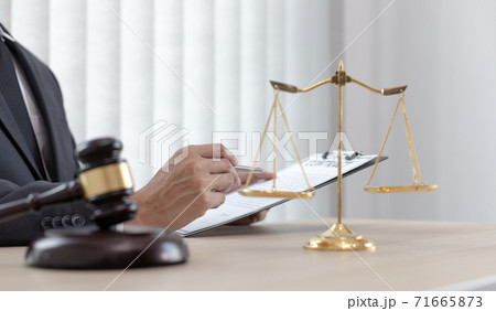 Judge or a lawyer works documents in the courtroom and analyze the various laws for justice and accuracy, Litigation and justice concept. Judge or a lawyer works documents in the courtroom and analyze the various laws for justice and accuracy, Litigation and justice concept. 71665873