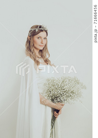 Elegant pretty woman elf with white flowers. Mysterious elven sorceress halloween character costume Elegant pretty woman elf with white flowers. Mysterious elven sorceress halloween character costume 71666456