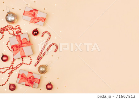 Christmas and New Year backdrop with copy space. Festively decorated  Gift boxes,  cane lollypops, christmas balls on golden banner. 71667812