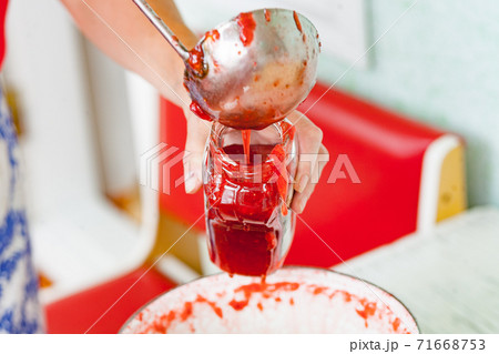 pour fresh strawberry jam into a jar with steel ladle pour fresh strawberry jam into a jar with steel ladle 71668753
