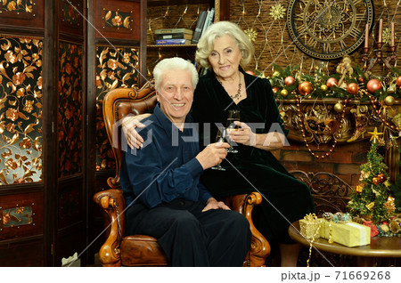 Happy senior couple with champagne on Christmas at home Happy senior couple with champagne on Christmas at home 71669268