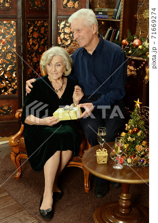 Happy senior couple with champagne on Christmas at home Happy senior couple with champagne on Christmas at home 71669274