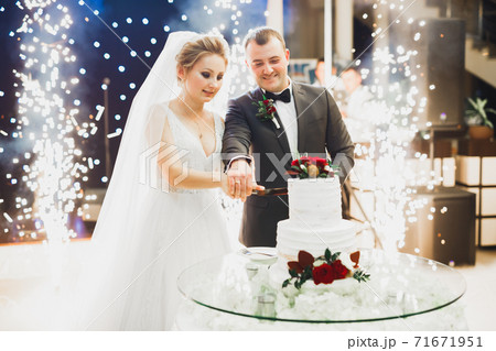 Bride and groom at wedding cutting the wedding cake Bride and groom at wedding cutting the wedding cake 71671951
