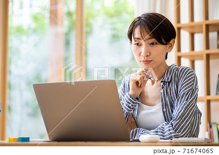 リビングでテレワーク中の女性 71674065