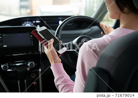 運転中にスマホ操作をする女性 運転中にスマホ操作をする女性 71679014