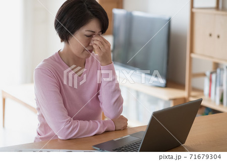 在宅ワーク中に疲れを感じる日本人女性 在宅ワーク中に疲れを感じる日本人女性 71679304