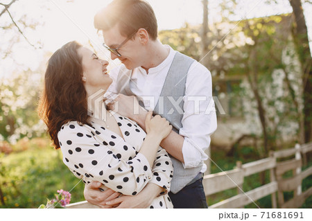 Young man and woman couple in a blooming garden 71681691