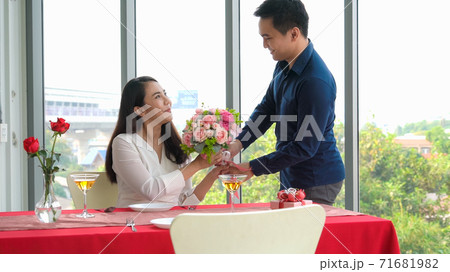 Romantic couple giving gift to lover at restaurant Romantic couple giving gift to lover at restaurant 71681982
