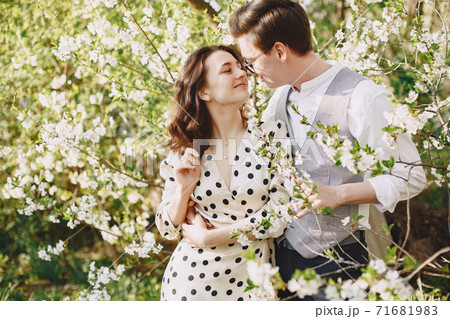 Young man and woman couple in a blooming garden 71681983