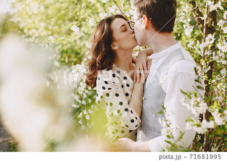 Young man and woman couple in a blooming garden Young man and woman couple in a blooming garden 71681995