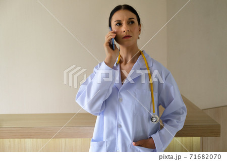 A female doctor is talking on the phone to inquire about the symptoms of the physical patient A female doctor is talking on the phone to inquire about the symptoms of the physical patient 71682070