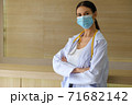 A female doctor wearing a mask is standing at the reception. 71682142