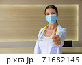 A female doctor wearing a medical mask raising his thumbs. 71682145