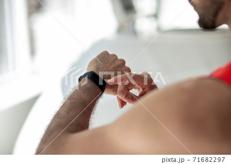 Close up picture of a mna looking at the smartwatch 71682297