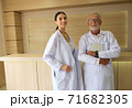 Two doctors were standing smiling in the reception hall. 71682305