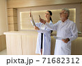 Two doctors were looking at the patient's record and discussing the patient's illness. 71682312