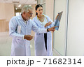 Two doctors were looking at the patient's record and discussing the patient's illness. 71682314