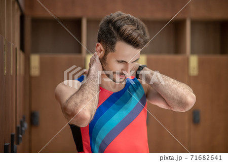 Sportsman in bright tshirt suffering from pain in his neck 71682641