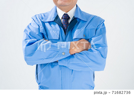 ビジネスシーン 作業服の男性 腕組みの写真素材