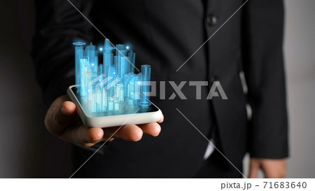 Businessman holds 3D city model showing augmented reality technology Businessman holds 3D city model showing augmented reality technology 71683640