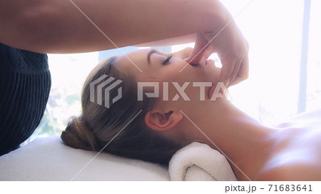 Woman gets facial and head massage in luxury spa. 71683641