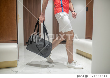 Close up picture of mans figure entering the changing room in the gym Close up picture of mans figure entering the changing room in the gym 71684611