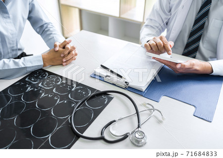 Professor Doctor consulting with patient discussing something and recommend treatment methods, Presenting results on report and x-ray film, Medicine and health care concept Professor Doctor consulting with patient discussing something and recommend treatment methods, Presenting results on report and x-ray film, Medicine and health care concept 71684833