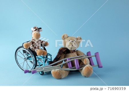 International day of persons with disabilities. Wheelchair with toys sign of different disabilities on blue background. International day of persons with disabilities. Wheelchair with toys sign of different disabilities on blue background. 71690359