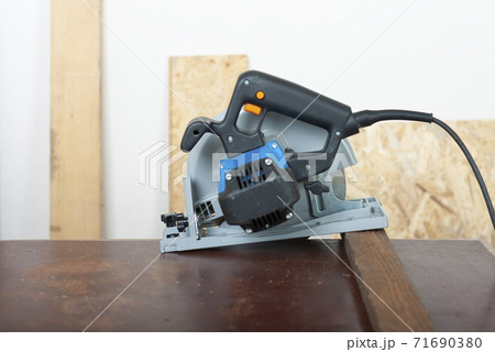 Electric hand tool circular saw on desk, on background oriented strand board 71690380
