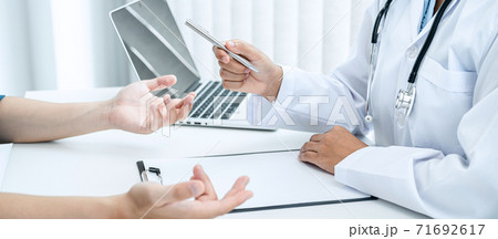 Doctor hold pen and patient discussing something in medical clinic 71692617