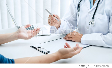 Doctor hold pen and patient discussing something in medical clinic 71692620
