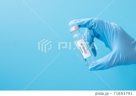 COVID-19 Vaccine vial against Coronavirus infection in hand of doctor with Nitrile Glove in hospital laboratory. Medical, health, Vaccination and immunization concept COVID-19 Vaccine vial against Coronavirus infection in hand of doctor with Nitrile Glove in hospital laboratory. Medical, health, Vaccination and immunization concept 71693791