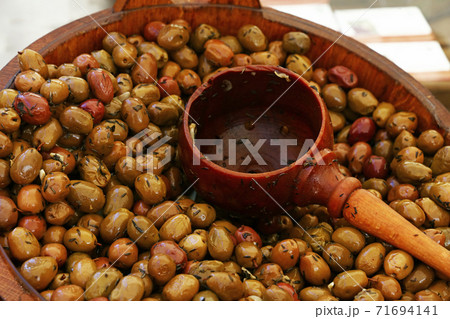 Pickled green olives and wooden scoop in a barrel Pickled green olives and wooden scoop in a barrel 71694141