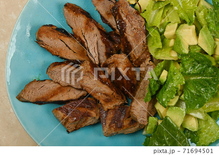 Grilled beef steak sliced and served with salad 71694501