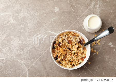 Bowl with granola and milk on gray background Bowl with granola and milk on gray background 71695017