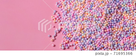 Pile of pastel color balls on pink. Styrofoam or Polystyrene foam background. Mix of colorful sugar balls, used to decorate baking and sweets. Rainbow colored sugar chips, dragee spins, confectionery Pile of pastel color balls on pink. Styrofoam or Polystyrene foam background. Mix of colorful sugar balls, used to decorate baking and sweets. Rainbow colored sugar chips, dragee spins, confectionery 71695366